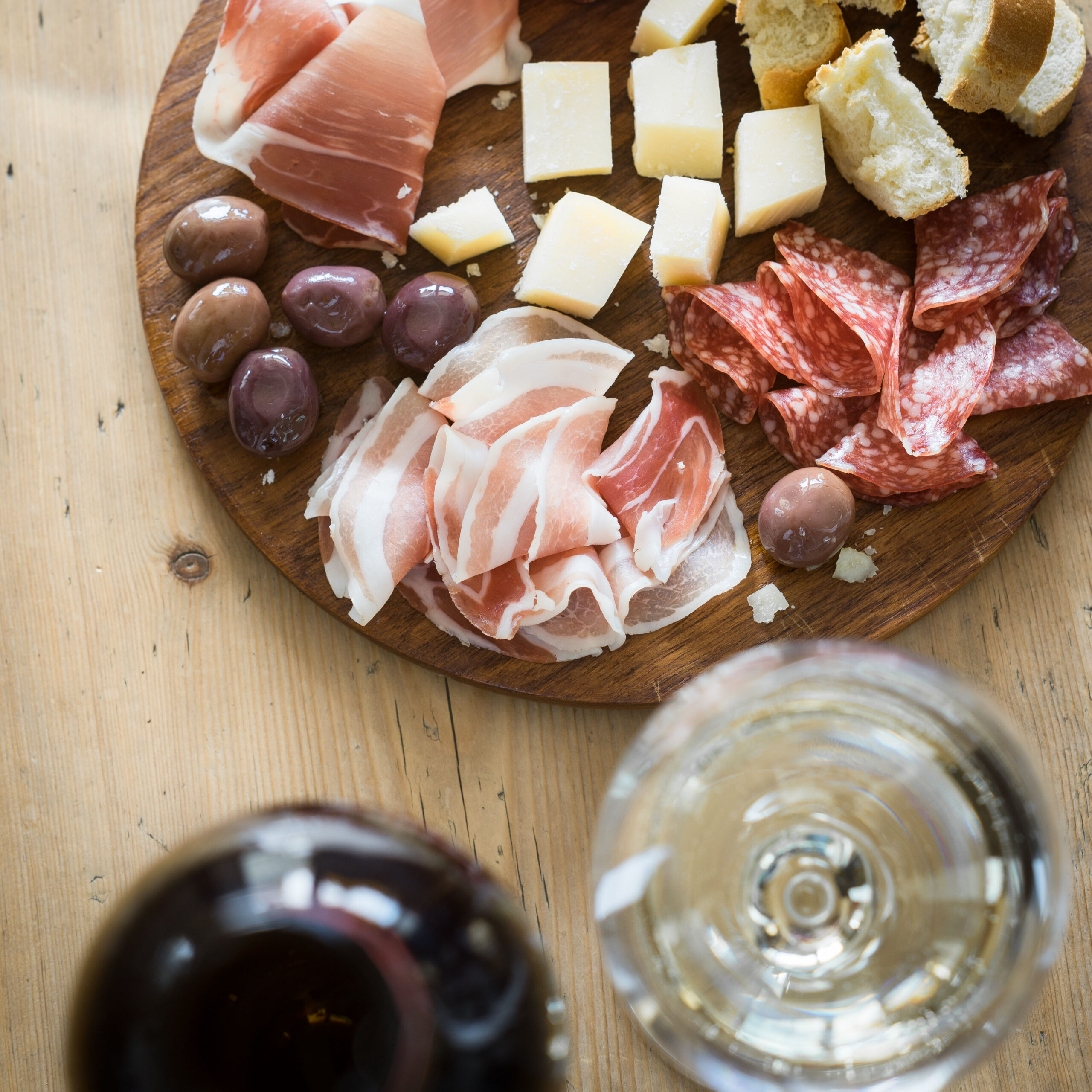 Traditional italian apero: white wine and plate with prosciutto